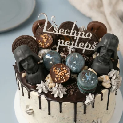 Horní detail dortu Star Wars s čokoládovým dripem, tmavými makronkami, sušenkami, pralinkami a nápisem Všechno nejlepší.