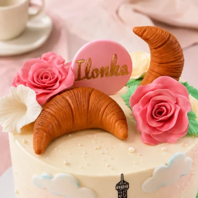 Horní detail Pařížského dortu s Eiffelovou věží, croissanty, růžemi a jemným romantickým zdobením.