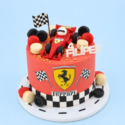 Dort s červenou formulí Ferrari, jezdcem v bílé přilbě, makronkami, pneumatikami a šachovnicovým lemem.
